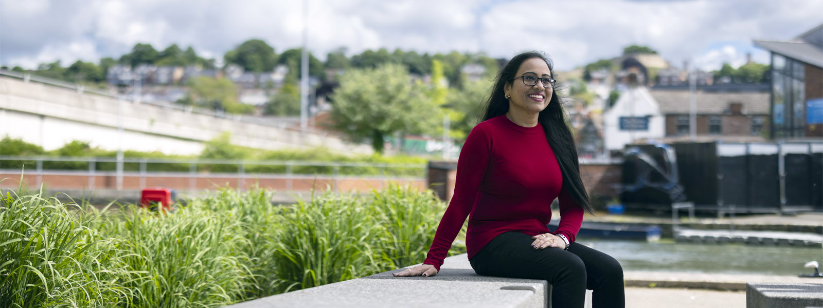 A student sat on a wall on campus