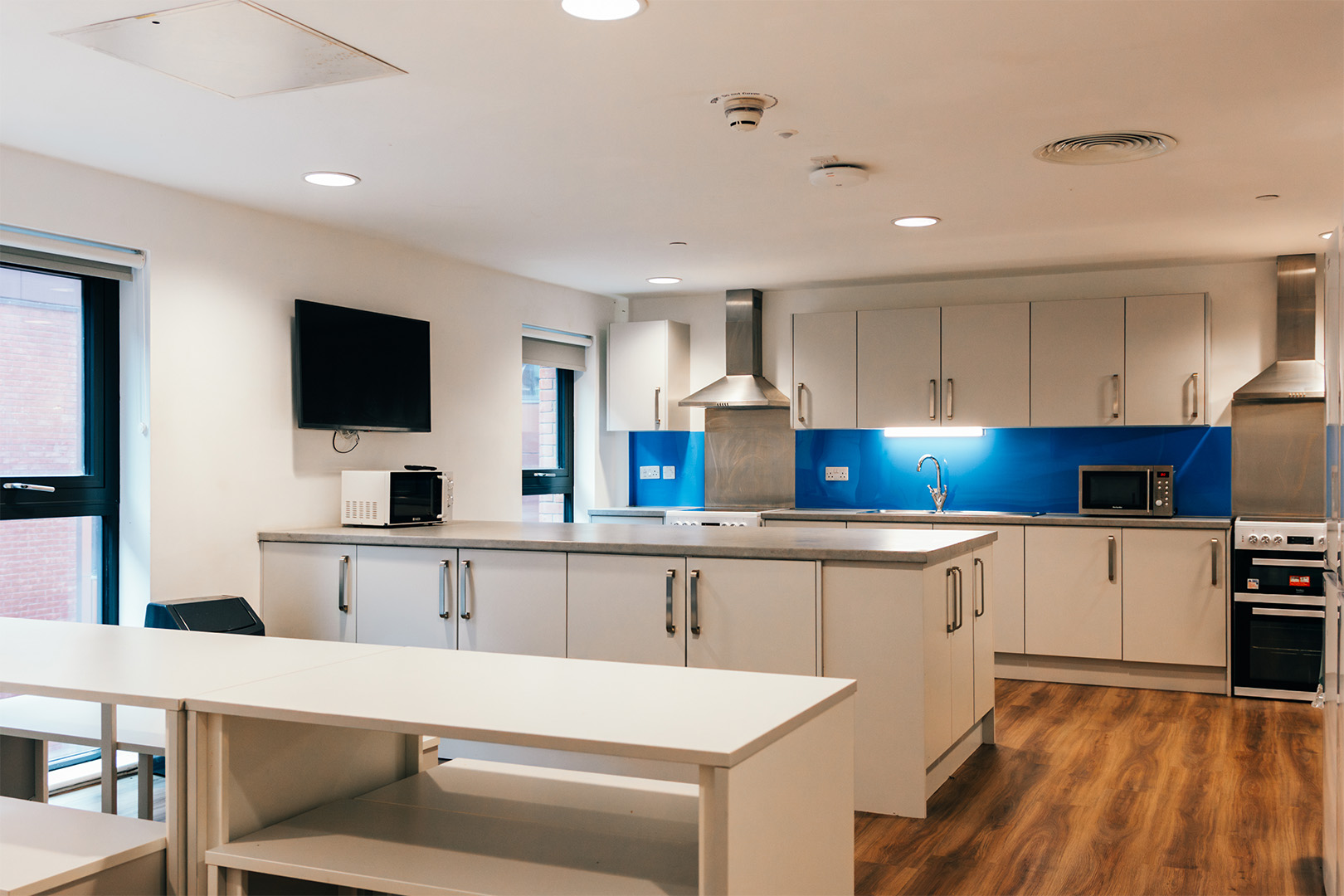 The inside of a kitchen with a dining table in the foreground