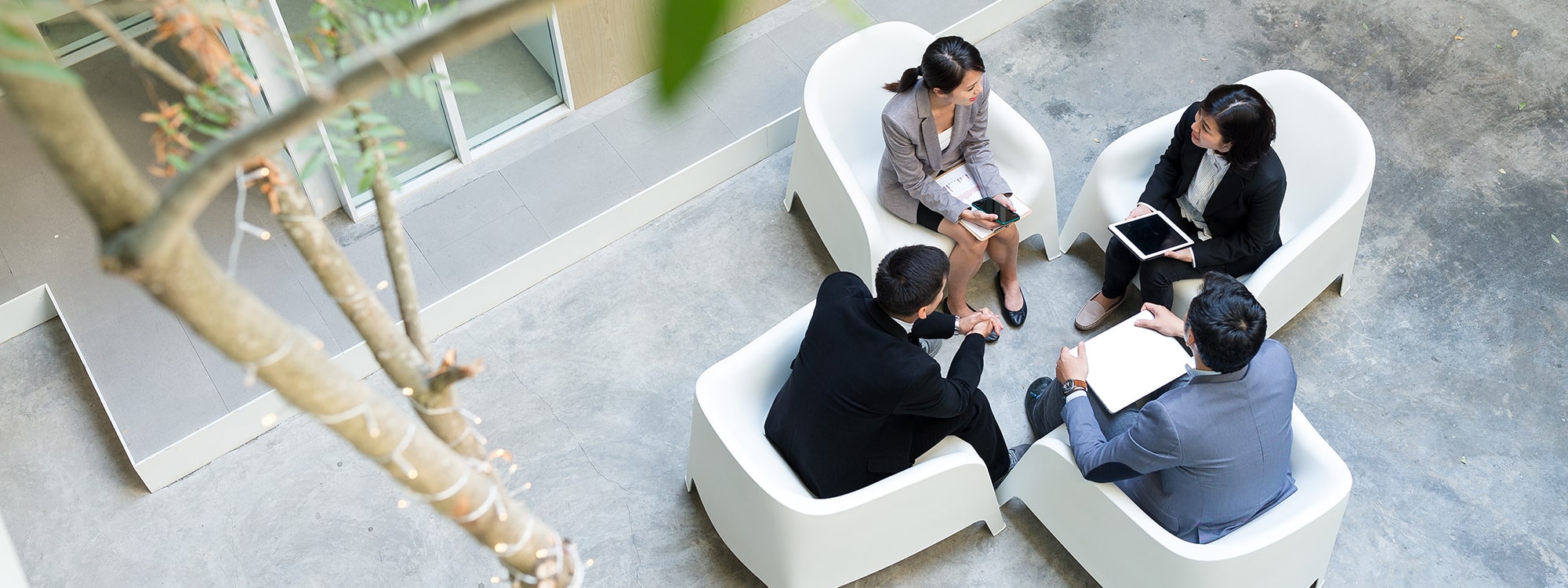 Four people sat down talking in a business meeting