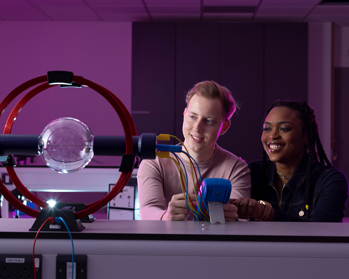 A male and female student conducting a physics experiment
